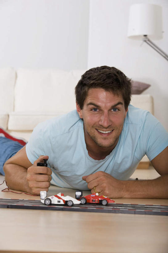 西方人,一个人,客厅,笑,微笑,露齿笑,竖图,室内,白天,正面,游戏,汽车,玩具,欧洲,欧洲人,仅一个男性,仅一个人,仅一个中年男性,握,服装,拿,玩,拿着,注视,娱乐,车,衣服,交通工具,轿车,观察,看,趴着,休闲,益智,握着,服饰,观看,活动,察看,起居室,衣着,穿着,发泄,关注,消遣,智力,载具,宣泄,衣饰,男人,男性,中年男性,白种人,趴,玩耍,嬉戏,半身,彩图