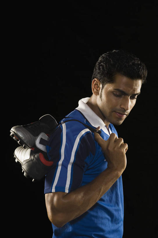 一个人,运动员,站,笑,微笑,竖图,室内,白天,侧面,运动服,鞋子,亚洲,仅一个男性,仅一个人,握,黑色背景,服装,带子,足球鞋,拿,足球运动员,拿着,注视,仅一个年轻男性,衣服,蓝色,观察,看,站着,握着,摄影,服饰,影棚,观看,察看,衣着,穿着,关注,衣饰,男人,男性,年轻男性,亚洲人,印度人,体育运动员,运动选手,半身,彩图,影棚拍摄,拍摄,运动装