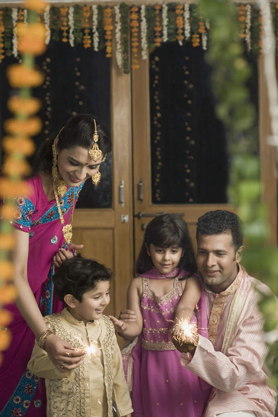 儿童,四个人,家庭,夫妻,母亲,父亲,女儿,儿子,站,蹲,笑,微笑,露齿笑,竖图,室外,白天,正面,民族服装,爱情,纯洁,门,项链,亚洲,朦胧,模糊,浪漫,拿,拿着,注视,装饰品,小孩,耳环,饰品,手链,首饰,门框,观察,看,站着,温暖,温馨,父女,父子,母女,母子,一家人,恩爱,父爱,可爱,母爱,童年,童趣,恋人,服饰,手镯,观看,飘逸,烟火棒,戴着,和睦,察看,庄重,关注,追求,镯子,童真,烂漫,无邪,纱丽,雅致,纱丽服,清婉,妍丽,天真,男孩,男人,男性,年轻男性,年轻女性,女孩,女人,女性,亚洲人,印度人,孩子,年轻人,夫妇,情侣,蹲着,站立,半身,彩图,传统服装,民俗服,伴侣,融洽,男生,女生,奢华