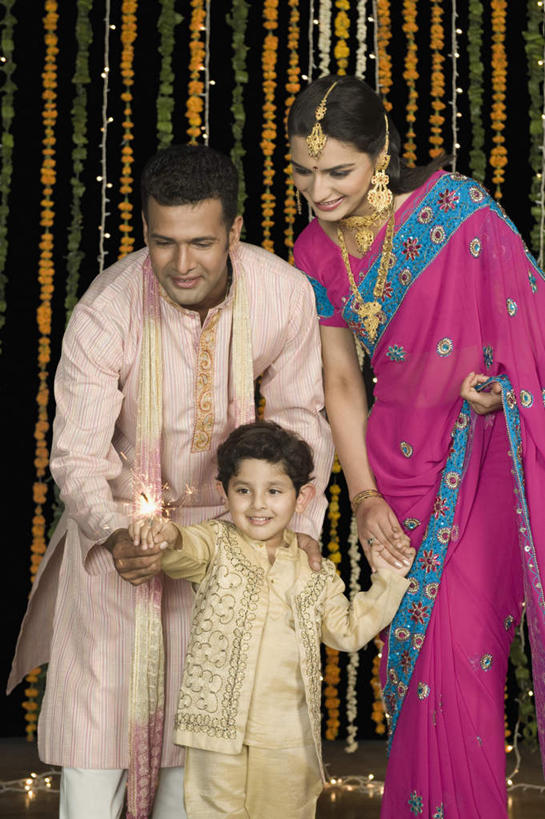 儿童,三个人,家庭,夫妻,母亲,父亲,儿子,站,笑,微笑,露齿笑,竖图,室内,白天,正面,民族服装,爱情,游戏,纯洁,项链,亚洲,浪漫,拿,玩,拿着,注视,娱乐,装饰品,小孩,耳环,饰品,手链,首饰,观察,看,站着,休闲,温暖,温馨,父子,母子,三口之家,一家人,恩爱,父爱,可爱,母爱,童年,童趣,恋人,服饰,手镯,观看,飘逸,烟火棒,戴着,和睦,察看,庄重,关注,追求,镯子,童真,烂漫,无邪,纱丽,雅致,纱丽服,清婉,妍丽,天真,男孩,男人,男性,年轻男性,年轻女性,女人,女性,亚洲人,印度人,孩子,年轻人,夫妇,情侣,搀手,拉手,手搀手,手拉手,手牵手,玩耍,嬉戏,站立,半身,彩图,传统服装,民俗服,伴侣,融洽,男生,奢华