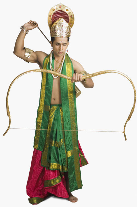 一个人,站,竖图,室内,白天,正面,民族服装,竞争,皇冠,项链,亚洲,仅一个男性,仅一个人,对抗,握,服装,冲突,弓,弓箭,拿,拿着,注视,破坏,表演者,装饰品,仅一个年轻男性,衣服,耳环,饰品,首饰,观察,看,站着,武器,战争,握着,服饰,观看,损坏,察看,攻击,威胁,衣着,穿着,对立,关注,矛盾,兵器,防御,印度文化,敌对,挫败,斗争,抗拒,抗衡,杀伤,威慑,耳饰,衣饰,危险,男人,男性,年轻男性,亚洲人,印度人,王冠,站立,彩图,全身,传统服装,民俗服