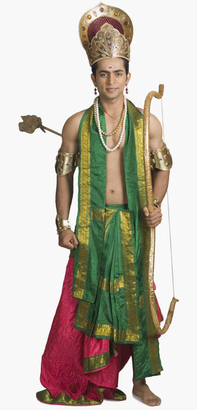 一个人,站,竖图,室内,白天,正面,民族服装,竞争,皇冠,项链,亚洲,仅一个男性,仅一个人,对抗,握,服装,冲突,弓,弓箭,拿,拿着,注视,破坏,表演者,装饰品,仅一个年轻男性,衣服,耳环,饰品,首饰,观察,看,站着,武器,战争,握着,服饰,观看,损坏,权威,察看,攻击,威胁,衣着,穿着,对立,高贵,关注,矛盾,兵器,防御,印度文化,敌对,挫败,斗争,抗拒,抗衡,杀伤,威慑,权力,统治,耳饰,衣饰,危险,男人,男性,年轻男性,亚洲人,印度人,王冠,站立,彩图,全身,传统服装,民俗服