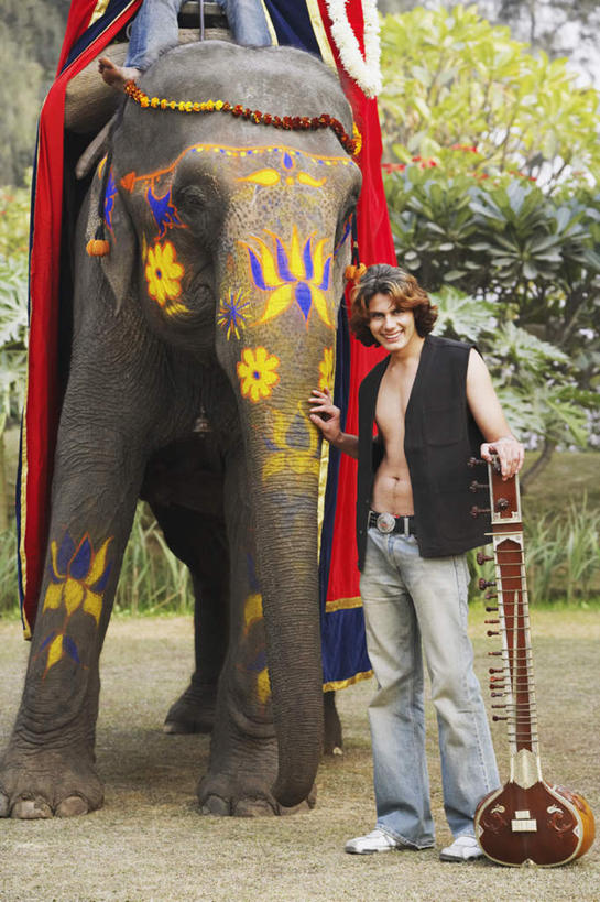 西方人,一个人,站,笑,摸,微笑,露齿笑,竖图,室外,白天,正面,树林,植物,靠垫,大象,野生动物,欧洲,欧洲人,仅一个男性,仅一个人,抚摸,花纹,服装,节日,艺术,彩绘,花环,图案,靠枕,乐器,弦乐器,休闲装,文化,树,树木,仅一个年轻男性,一个,衣服,绿色,白色,自然,动物,垫子,枕头,祈祷,站着,休闲,健康,休闲服,可爱,许愿,宗教,服饰,信仰,活泼,生长,成长,纪念,华丽,祈求,弓拉弦乐器,弓拉弦鸣乐器,凶猛,人体彩绘,印度文化,美观,西塔尔,西塔琴,纹身彩绘,锡塔尔琴,平安,男人,男性,年轻男性,白种人,触摸,接触,站立,彩图,全身