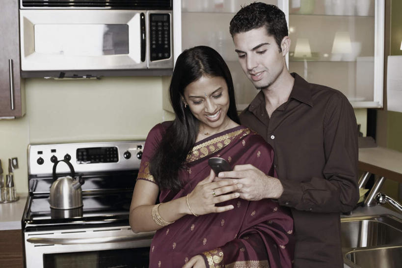 两个人,站,笑,打电话,微笑,露齿笑,横图,室内,白天,正面,民族服装,爱情,厨房,厨具,电话,手机,亚洲,握,服装,灶台,浪漫,拿,拿着,注视,休闲装,通讯设备,衣服,观察,看,靠,靠着,站着,休闲,温暖,温馨,休闲服,恩爱,握着,恋人,服饰,观看,飘逸,碗柜,和睦,察看,庄重,关注,追求,纱丽,雅致,纱丽服,清婉,妍丽,交流,男人,男性,年轻男性,年轻女性,女人,女性,亚洲人,印度人,情侣,储藏用具,进餐用具,烹调用具,洗涤用具,沟通,通话,站立,半身,彩图,传统服装,民俗服,灶间,伴侣,融洽,奢华,调理用具