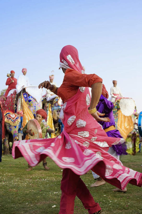 两个人,竖图,室外,白天,侧面,民族服装,跳舞,草地,草坪,植物,纺织品,亚洲,阴影,光线,影子,手工制品,许多人,图像,注视,草,蓝色,绿色,蓝天,天空,阳光,工艺品,天,观察,看,一群人,晴朗,观看,察看,关注,舞姿,万里无云,构图,式样,男人,男性,女人,女性,中年男性,中年女性,亚洲人,印度人,晴空,晴空万里,半身,彩图,传统服装,民俗服,舞蹈