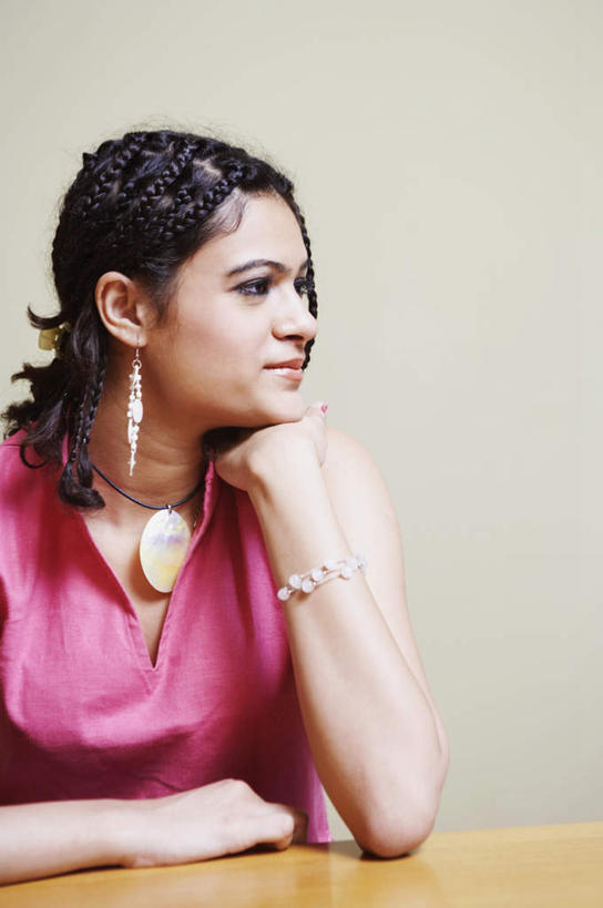 一个人,坐,竖图,室内,白天,正面,裙子,餐桌,桌面,桌子,亚洲,仅一个年轻女性,仅一个女性,仅一个人,连衣裙,服装,木制,注视,装饰品,衣服,红色,耳环,木制品,饰品,手链,首饰,观察,看,斜视,服饰,手镯,餐台,观看,察看,衣着,穿着,关注,镯子,耳饰,衣饰,年轻女性,女人,女性,亚洲人,印度人,坐着,半身,彩图