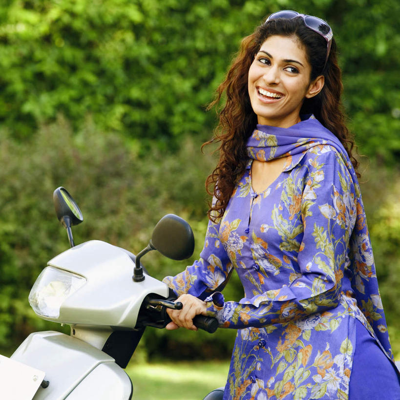 一个人,站,笑,微笑,露齿笑,方图,室外,白天,侧面,民族服装,草地,草坪,森林,树林,植物,亚洲,仅一个年轻女性,仅一个女性,仅一个人,阴影,环保,朦胧,模糊,光线,墨镜,眼镜,影子,防护,注视,车,草,树,树木,绿色,紫色,阳光,自然,太阳镜,太阳眼镜,交通工具,观察,看,站着,遮阳镜,服饰,助动车,生长,成长,观看,飘逸,察看,庄重,关注,美好,美妙,追求,间隔,纱丽,美观,雅致,雅观,纱丽服,清婉,妍丽,绿篱,生篱,树篱,植篱,年轻女性,女人,女性,亚洲人,印度人,站立,半身,彩图,传统服装,民俗服,奢华