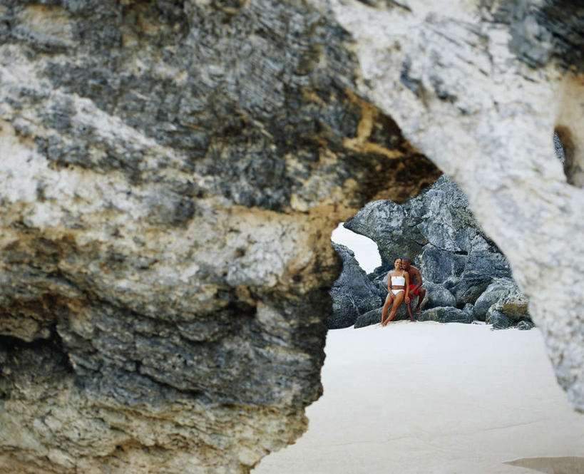 西方人,两个人,坐,横图,室外,白天,正面,泳装,比基尼,爱情,石头,沙滩,欧洲,非洲,黑人,欧洲人,短裤,裤子,沙子,石子,海岸,沙地,浪漫,注视,红色,观察,看,温暖,温馨,恩爱,沙滩裤,恋人,观看,和睦,察看,关注,男人,男性,年轻男性,年轻女性,女人,女性,白种人,非洲人,情侣,海滩,石块,岩石,坐着,彩图,全身,三点式,泳衣,伴侣,融洽