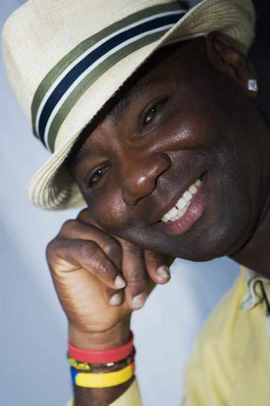 西方人,脸,头,脸颊,手,一个人,笑,微笑,露齿笑,竖图,室内,特写,白天,正面,帽子,欧洲,非洲,黑人,欧洲人,仅一个男性,仅一个人,仅一个中年男性,撑,服装,托腮,注视,休闲装,装饰品,衣服,耳环,饰品,手链,首饰,遮阳帽,观察,看,托,休闲,手部,休闲服,服饰,手镯,观看,单手,察看,关注,托下巴,镯子,耳饰,男人,男性,中年男性,非洲人,头部,脸部,脸蛋,面部,半身,彩图