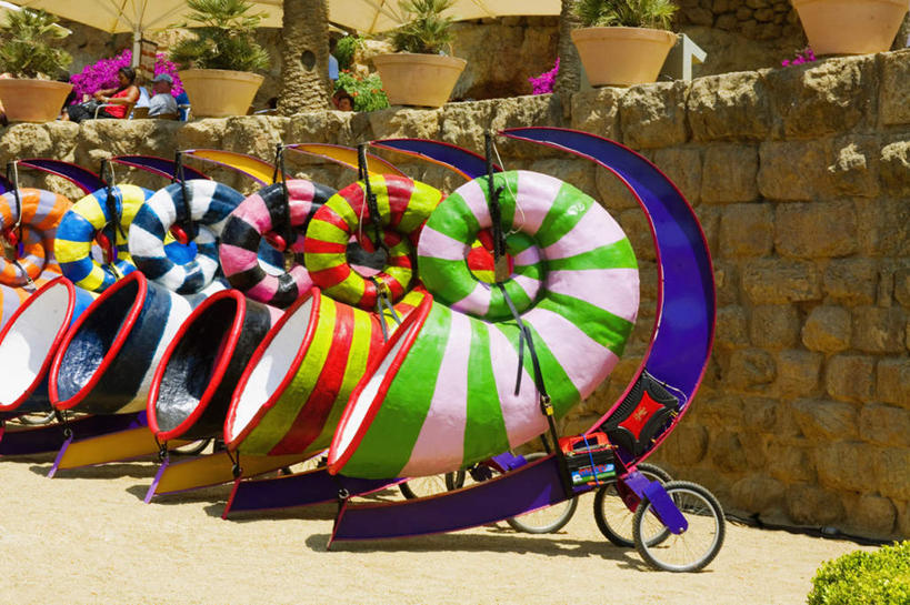 西方人,公园,坐,横图,室外,白天,正面,度假,石头,美景,植物,餐桌,桌子,城市风光,城市,帽子,椅子,西班牙,欧洲,巴塞罗那,欧洲人,一排,许多,行人,游客,游人,阴影,服装,整齐,装饰,光线,盆栽,伞,石子,影子,雨伞,遮阳伞,墙,景观,盆景,许多人,注视,休闲装,娱乐,阳伞,运动帽,路人,旅客,墙壁,墙面,排列,衣服,绿色,阳光,自然,观察,看,一群人,享受,休闲,休闲服,鸭舌帽,景色,放松,服饰,生长,成长,餐台,观看,华丽,修饰,点缀,察看,太阳伞,队列,关注,南欧,咖啡店,咖啡屋,奎尔公园,首府,古埃尔公园,加泰罗尼亚,西班牙王国,衬托,美观,雅致,雅观,过客,男人,男性,女人,女性,中年男性,中年女性,白种人,石块,岩石,坐着,半身,彩图,咖啡馆