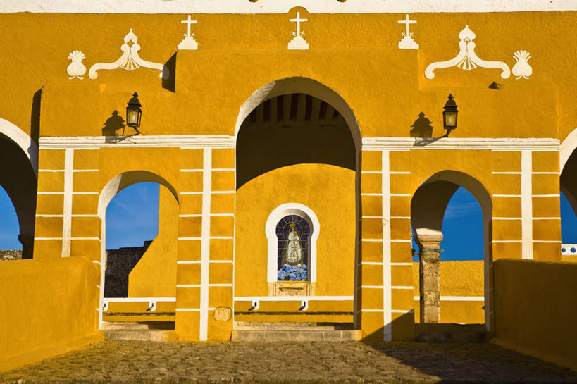 无人,横图,室外,白天,正面,旅游,度假,石头,门,标志建筑,地标,建筑,照明,墨西哥,阴影,节日,光线,壁灯,石子,影子,墙,拱门,灯光,文化,娱乐,建设,墙壁,墙面,灯,黄色,蓝色,蓝天,天空,阳光,灯具,门框,天,祈祷,享受,休闲,健康,旅游胜地,放松,许愿,宗教,信仰,晴朗,纪念,祈求,照亮,北美,北美洲,基督教,照明设备,天主教,修道院,美洲,信念,万里无云,尤卡坦半岛,尤卡坦州,北亚美利加洲,亚美利加洲,墨西哥合众国,仙人掌王国,加敦半岛,犹加敦,神学院,修院,隐修院,平安,石块,晴空,晴空万里,彩图