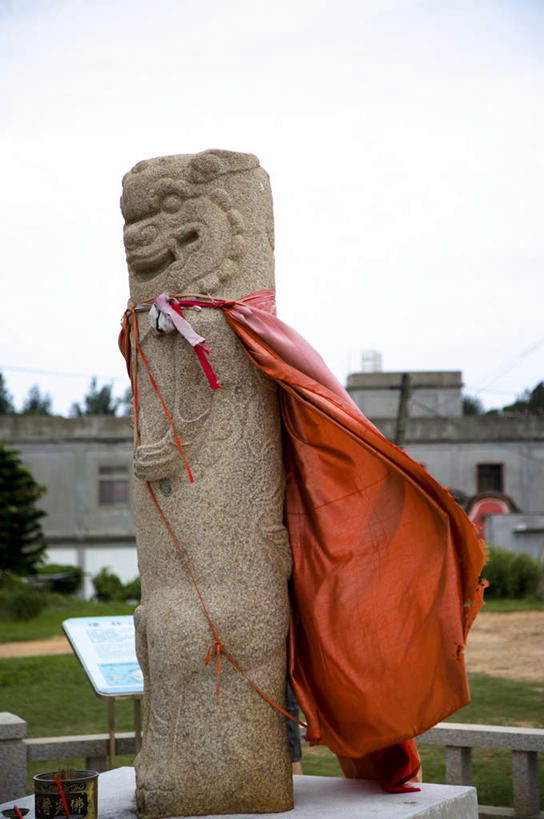 无人,竖图,室外,白天,侧面,旅游,度假,草地,草坪,植物,标志建筑,地标,建筑,哺乳动物,野生动物,狮子,雕塑,台湾,中国,亚洲,阴影,艺术,装饰,光线,雕刻,雕像,影子,云,云朵,云彩,娱乐,建设,石雕,草,树,树木,红色,蓝色,绿色,白云,蓝天,天空,阳光,自然,动物,工艺品,天,享受,休闲,旅游胜地,放松,生长,晴朗,成长,纪念,美术,主题,凶猛,斗篷,陈列,东亚,港澳台,中华人民共和国,功能,美学,台湾省,大氅,残暴,凶残,晴空,彩图,全身,金门,金门县,风狮,风狮爷,石狮公,石狮爷,台