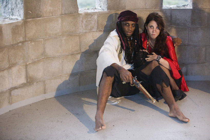 西方人,两个人,坐,横图,室内,白天,正面,竞争,建材,建筑,项链,欧洲,非洲,黑人,欧洲人,对抗,握,阴影,服装,冲突,反射,材料,瓷砖,地砖,枪支,头巾,影子,砖,砖块,墙,地面,注视,破坏,墙壁,墙面,装饰品,衣服,饰品,手链,首饰,观察,看,武器,砖头,战争,握着,海盗,建造,服饰,手枪,手镯,观看,损坏,察看,攻击,威胁,衣着,穿着,对立,关注,矛盾,兵器,防御,镯子,表演服,枪械,演出服,弹夹,敌对,挫败,斗争,抗拒,抗衡,杀伤,威慑,衣饰,子弹夹,道具服,危险,男人,男性,年轻男性,年轻女性,女人,女性,白种人,非洲人,石料,坐着,彩图,全身,砌墙砖