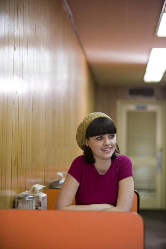 西方人,一个人,坐,笑,微笑,露齿笑,竖图,室内,白天,正面,餐桌,桌子,帽子,欧洲,欧洲人,仅一个年轻女性,仅一个女性,仅一个人,服装,墙,扭头,注视,休闲装,纸巾盒,墙壁,墙面,衣服,观察,看,转头,休闲,休闲服,服饰,餐台,观看,察看,关注,咖啡店,贝雷帽,咖啡屋,年轻女性,女人,女性,白种人,坐着,半身,彩图,咖啡馆