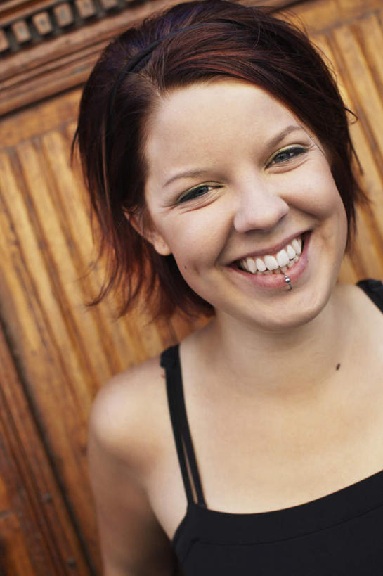 西方人,脸,头,脸颊,一个人,站,笑,微笑,露齿笑,竖图,室外,特写,白天,正面,门,欧洲,欧洲人,仅一个年轻女性,仅一个女性,仅一个人,墙,注视,墙壁,墙面,门框,观察,看,站着,观看,察看,关注,唇钉,年轻女性,女人,女性,白种人,头部,脸部,脸蛋,面部,站立,半身,彩图