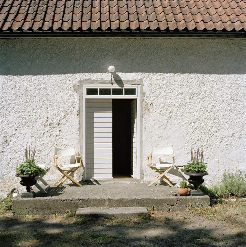 无人,竖图,室外,白天,正面,植物,门,建筑,椅子,阴影,装饰,光线,木制,盆栽,瓦片,影子,房屋,木椅,墙,屋顶,屋子,公寓,盆景,两盆,顶棚,瓦,楼房,墙壁,墙面,住宅,两个,红色,绿色,白色,阳光,自然,木制品,门框,建造,生长,成长,华丽,修饰,点缀,屋瓦,衬托,美观,雅致,雅观,彩图,房子