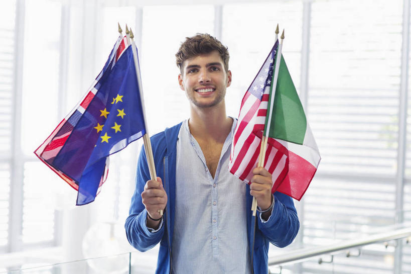 西方人,一个人,机场,站,笑,微笑,露齿笑,横图,室内,白天,正面,窗户,落地窗,飞机场,旗帜,国旗,欧洲,欧洲人,仅一个男性,仅一个人,握,阴影,服装,反射,影子,拿,拿着,注视,休闲装,星条旗,玻璃窗,仅一个年轻男性,衣服,英国国旗,观察,看,站着,休闲,休闲服,握着,美国国旗,服饰,观看,察看,米字旗,关注,意大利国旗,欧盟旗帜,男人,男性,年轻男性,白种人,航空站,空港,旗,站立,半身,彩图,美利坚合众国国旗,三色旗