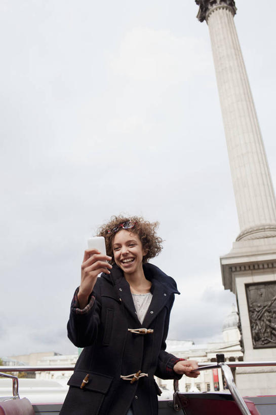 西方人,一个人,站,笑,打电话,微笑,露齿笑,竖图,室外,白天,仰视,公共汽车,电话,手机,欧洲,欧洲人,仅一个年轻女性,仅一个女性,仅一个人,握,服装,巴士,公交车,拿,拿着,注视,休闲装,通讯设备,双层巴士,车,拍照,衣服,天空,交通工具,天,观察,看,站着,休闲,休闲服,握着,摄影,服饰,观看,察看,关注,载具,一部,双层公共汽车,观光巴士,交流,年轻女性,女人,女性,白种人,沟通,通话,站立,半身,彩图,低角度拍摄,照相