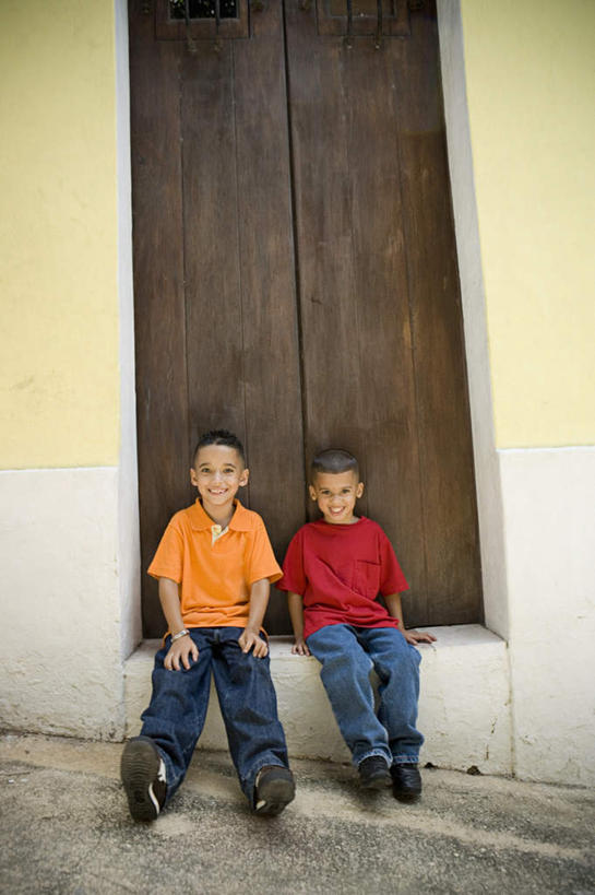 西方人,儿童,两个人,伙伴,朋友,坐,笑,微笑,露齿笑,竖图,室外,白天,正面,友谊,地板,欧洲,欧洲人,握,服装,裤子,墙,棕色,地面,拿,拿着,注视,牛仔裤,休闲装,翘腿,木地板,墙壁,墙面,画,门板,小孩,衣服,观察,看,靠,靠着,倚靠,休闲,同学,休闲服,握着,服饰,观看,察看,倚着,关注,友情,男孩,男人,男性,白种人,坐着,彩图,全身,男生