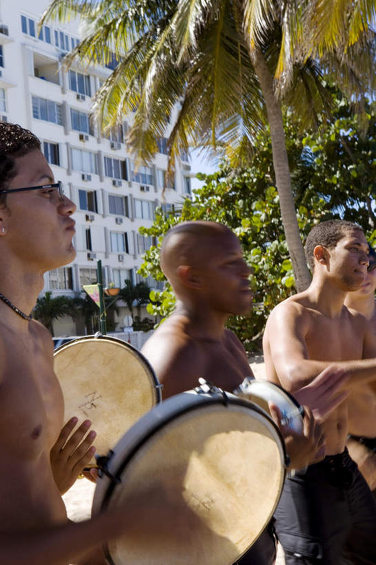 西方人,三个人,伙伴,朋友,家,站,举,笑,微笑,露齿笑,竖图,室外,白天,正面,旅游,度假,游戏,友谊,沙滩,树林,植物,项链,欧洲,欧洲人,沙子,眼镜,泳镜,房屋,屋子,鼓,沙地,玩,注视,娱乐,打鼓,楼房,住宅,装饰品,树,树干,树木,绿色,自然,饰品,首饰,游泳眼镜,观察,看,托,站着,享受,休闲,放松,生长,成长,观看,活动,察看,发泄,关注,消遣,智力,宣泄,友情,男人,男性,年轻男性,白种人,海滩,举起,举手,举着,玩耍,嬉戏,向上举,向上伸,向上托,站立,半身,彩图,房子