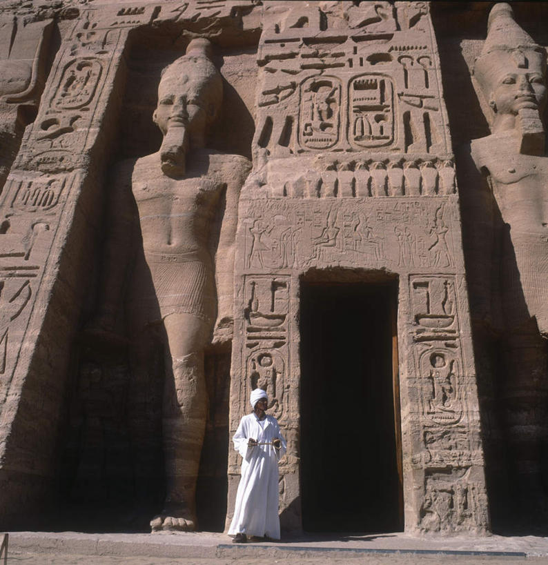 西方人,一个人,寺庙,站,竖图,室外,白天,正面,民族服装,旅游,度假,名胜古迹,标志建筑,城市,地标,建筑,雕塑,欧洲,非洲,埃及,黑人,欧洲人,仅一个男性,仅一个人,仅一个中年男性,阴影,节日,遗迹,艺术,装饰,光线,标志,雕刻,雕像,头巾,文字,影子,字符,字母,墙,燃烧,注视,古迹,文化,文物,娱乐,标识,建设,古建筑,废墟,墙壁,墙面,白色,阳光,香火,工艺品,庙宇,观察,看,祈祷,站着,享受,休闲,健康,旅游胜地,放松,许愿,宗教,信仰,观看,纪念,华丽,修饰,祈求,美术,点缀,察看,古埃及,法老,关注,主题,陈列,埃及法老,古文明,北非,首府,吉萨,阿拉伯埃及共和国,金字塔之国,棉花之国,功能,美学,衬托,美观,雅致,雅观,阿非利加洲,吉萨省,拉美西斯二世,墓穴,泉台,平安,男人,男性,中年男性,非洲人,站立,彩图,全身,传统服装,民俗服,庙,寺