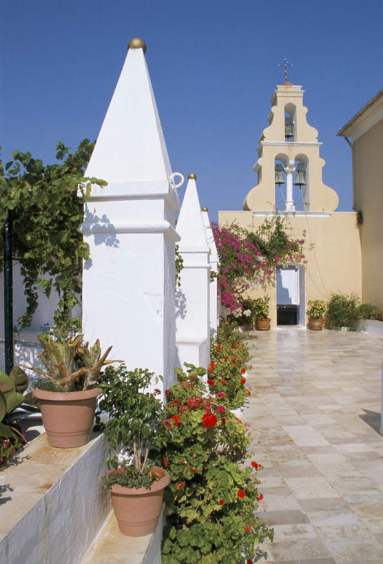 无人,家,竖图,室外,白天,正面,旅游,度假,植物,标志建筑,地标,建筑,希腊,欧洲,阴影,节日,盛开,光线,盆栽,影子,房屋,屋子,盆景,花蕾,文化,娱乐,建设,楼房,住宅,花,花瓣,花朵,鲜花,祈愿,蓝色,绿色,蓝天,天空,阳光,自然,天,花苞,花蕊,祈祷,享受,休闲,健康,旅游胜地,放松,许愿,宗教,信仰,生长,晴朗,成长,纪念,祈求,信号,基督教,天主教,修道院,报时,信念,希腊共和国,万里无云,召集,爱奥尼亚群岛,伊奥尼亚群岛,神学院,修院,隐修院,鸣钟,科孚岛,克基拉岛,平安,钟,晴空,晴空万里,彩图,房子