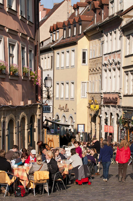 西方人,家,商店,站,坐,走,说,竖图,俯视,室外,白天,度假,讨论,美景,植物,桌子,城市风光,城市,杯子,帽子,椅子,德国,欧洲,欧洲人,行人,游客,游人,阴影,服装,朦胧,模糊,盛开,光线,布料,瓷器,盆栽,影子,房屋,木椅,屋子,景观,公寓,小巷,咖啡杯,盆景,陶瓷制品,许多人,花蕾,布纹,注视,休闲装,娱乐,商铺,运动帽,洋房,楼房,路人,旅客,住宅,桌布,花,花瓣,花朵,鲜花,衣服,绿色,阳光,自然,餐巾,台布,花苞,花蕊,观察,看,站着,一群人,享受,休闲,休闲服,鸭舌帽,景色,放松,服饰,生长,成长,观看,察看,西欧,关注,瓷杯,德意志联邦共和国,巴伐利亚,巴伐利亚州,拜恩州,拜恩自由州,市肆,商号,冷巷,过客,班贝克,交流,男人,男性,年轻男性,年轻女性,女人,女性,白种人,步行,沟通,讲话,交谈,散步,商讨,说话,谈话,站立,走路,坐着,彩图,高角度拍摄,全身,房子,店铺