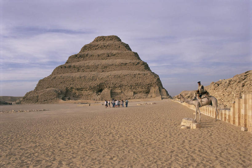 西方人,站,坐,横图,室外,白天,仰视,旅游,度假,石头,名胜古迹,沙漠,植物,地标,野生动物,欧洲,非洲,埃及,黑人,欧洲人,行人,游客,游人,握,阴影,服装,朦胧,模糊,遗迹,光线,石子,影子,云,云朵,许多人,云彩,注视,休闲装,古迹,历史,文物,娱乐,古建筑,骆驼,路人,旅客,树,树木,衣服,黄色,蓝色,绿色,白云,蓝天,天空,阳光,自然,动物,天,观察,看,站着,一群人,享受,休闲,休闲服,旅游胜地,金字塔,放松,握着,运输,服饰,生长,晴朗,成长,观看,察看,古埃及,关注,古文明,北非,萨卡拉,沙漠之舟,古代七大奇迹,阿拉伯埃及共和国,金字塔之国,棉花之国,阿非利加洲,双峰骆驼,过客,阶梯金字塔,塞加拉,圣卡拉梯形金字塔,男人,男性,女人,女性,中年男性,中年女性,非洲人,大漠,砂漠,石块,岩石,晴空,站立,坐着,彩图,低角度拍摄,全身,标志性建筑