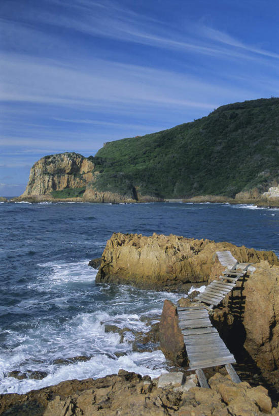 无人,竖图,室外,白天,正面,旅游,度假,海浪,海洋,石头,美景,森林,山,山脉,树林,植物,非洲,南非,阴影,飞溅,溅,光线,木板,石子,液体,影子,海面,景观,浪花,山顶,山峰,水滴,悬崖,云,云朵,桥,木桥,山峦,云彩,娱乐,栈桥,水珠,树,树木,蓝色,绿色,白云,蓝天,天空,阳光,自然,海水,群山,天,享受,休闲,景色,放松,生长,晴朗,成长,人行桥,木板桥,涨潮,碰撞,喷洒,自然风光,海景,海潮,沉积岩,绝壁,阿非利加洲,南非共和国,西开普省,颠峰,极峰,潮水,潮汐,落潮,克尼斯纳,水成岩,花园大道,大海,风浪,海,海水的波动,近岸浪,石块,岩石,涌浪,晴空,彩图