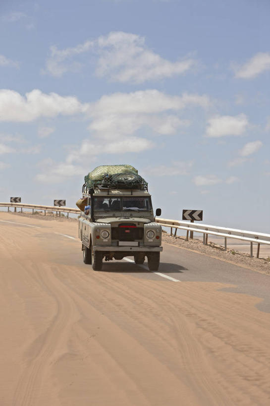 一个人,栏杆,竖图,室外,白天,高速公路,指示牌,越野车,汽车,非洲,摩洛哥,朦胧,模糊,弯曲,标志,沙子,文字,集装箱,警告,标识,货柜,车,容器,箱子,交通工具,警示,运输,摄影,禁止,提醒,提示,限制,载具,驾车,吉普车,北非,物流,撒哈拉沙漠,危险,彩图,路虎