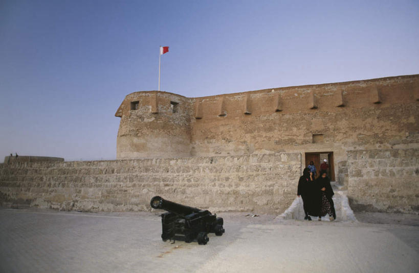 两个人,站,横图,室外,白天,仰视,旅游,度假,荒凉,名胜古迹,门,标志建筑,地标,建筑,旗帜,巴林,亚洲,阴影,服装,遗迹,光线,影子,荒野,荒漠,休闲装,古迹,文物,娱乐,旗子,建设,古建筑,衣服,蓝色,蓝天,天空,阳光,门框,天,站着,享受,休闲,休闲服,旅游胜地,放松,战争,服饰,炮台,西亚,荒原,战斗,古文明,旌旗,旗号,战役,冷落,巴林国,男人,男性,女人,女性,中年男性,中年女性,阿拉伯人,白种人,亚洲人,荒芜,站立,彩图,低角度拍摄,全身