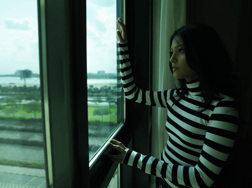 一个人,站,笑,微笑,露齿笑,横图,室内,白天,侧面,植物,窗户,亚洲,仅一个年轻女性,仅一个女性,仅一个人,阴影,服装,光线,影子,云,云朵,云彩,注视,休闲装,玻璃窗,树,树木,衣服,蓝色,绿色,白色,黑色,白云,蓝天,天空,阳光,自然,天,观察,看,站着,休闲,休闲服,忧伤,服饰,生长,晴朗,成长,观看,察看,难过,关注,忧郁,年轻女性,女人,女性,阿拉伯人,白种人,亚洲人,晴空,站立,半身,彩图,哀伤