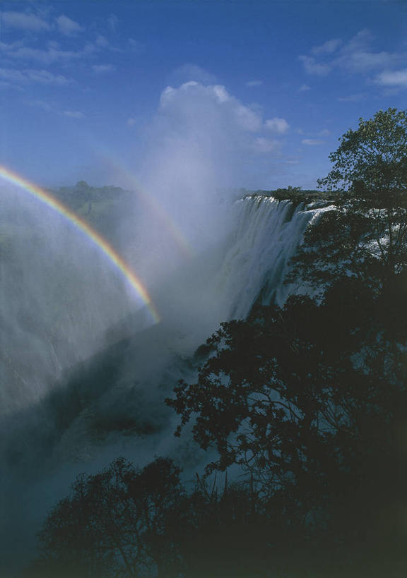 西方人,无人,竖图,室外,白天,仰视,彩虹,瀑布,水,欧洲,非洲,赞比亚,黑人,欧洲人,光,流水,云,联合国,树,风景,天空,自然,地标建筑,摄影,宁静,国家公园,自然现象,维多利亚瀑布,光谱,非洲人,彩图,低角度拍摄,旅行,莫西奥图尼亚国家公园,联合国教科文组织,郊野公园