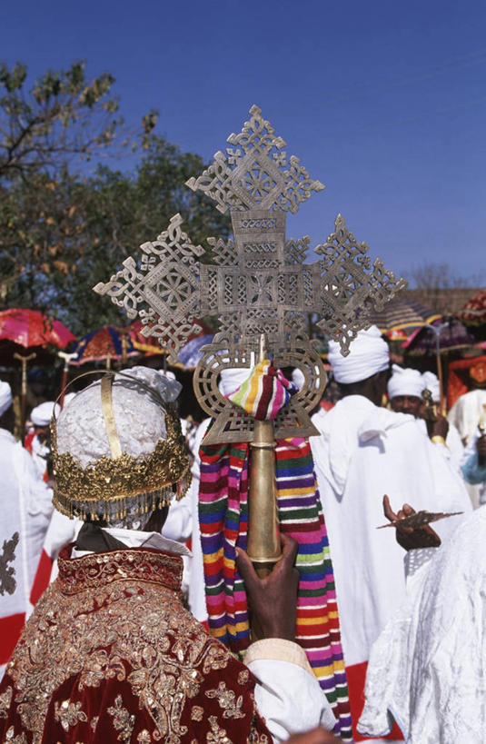 成年人,竖图,室外,白天,非洲,埃塞俄比亚,条纹,金属,长袍,十字架,头巾,头饰,许多人,拿着,树,背面,一群人,摄影,宗教,基督教,万里无云,阿非利加洲,埃塞俄比亚联邦民主共和国,拉利贝拉,阿姆哈拉州,神父,彩图,顿悟
