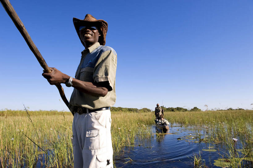 西方人,一个人,站,横图,室外,白天,正面,草地,草坪,河流,美景,水,植物,船,帽子,欧洲,非洲,博茨瓦纳,黑人,欧洲人,仅一个男性,仅一个人,仅一个中年男性,握,阴影,波纹,服装,时间,光线,船桨,墨镜,时钟,手表,眼镜,影子,河水,景观,水流,木船,涟漪,计时,注视,休闲装,草,衣服,蓝色,绿色,蓝天,水纹,天空,阳光,自然,太阳镜,太阳眼镜,遮阳帽,钟表,交通工具,波浪,天,观察,看,站着,休闲,休闲服,表,遮阳镜,景色,握着,服饰,晴朗,观看,腕表,察看,舟,关注,自然风光,载具,万里无云,奥卡万戈三角洲,水晕,奥卡万戈沼泽,波札那,博茨瓦纳共和国,男人,男性,中年男性,非洲人,钟,晴空,晴空万里,站立,半身,彩图,西北区