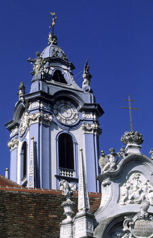 无人,教堂,竖图,室外,白天,仰视,旅游,度假,名胜古迹,标志建筑,地标,建筑,奥地利,欧洲,阴影,节日,遗迹,时间,光线,时钟,瓦片,影子,柱子,墙,屋顶,屋檐,钟楼,计时,顶棚,古迹,文化,文物,娱乐,建设,古建筑,檐,墙壁,墙面,蓝色,白色,蓝天,天空,阳光,钟表,天,祈祷,享受,休闲,健康,表,旅游胜地,放松,许愿,宗教,信仰,晴朗,纪念,祈求,信念,古文明,中欧,万里无云,塔钟,奥地利共和国,下奥地利,下奥地利州,平安,钟,晴空,晴空万里,彩图,低角度拍摄,大教堂,礼拜堂,克雷姆斯兰县,杜伦施坦