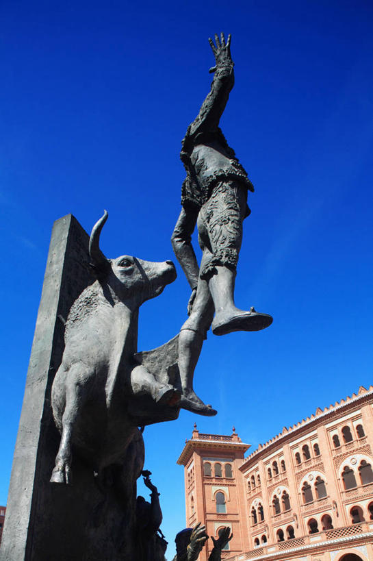 西方人,一个人,无人,站,竖图,室外,白天,仰视,旅游,度假,名胜古迹,窗户,标志建筑,地标,建筑,牛,雕塑,西班牙,欧洲,欧洲人,仅一个男性,仅一个人,一排,许多,阴影,遗迹,艺术,整齐,装饰,并列,并排,光线,雕刻,雕像,影子,墙,褐色,首都,很多,古迹,文物,娱乐,建设,古建筑,斗牛场,玻璃窗,墙壁,墙面,排列,仅一个年轻男性,蓝色,蓝天,天空,阳光,动物,工艺品,天,站着,享受,休闲,马德里,旅游胜地,家畜,放松,牲畜,晴朗,纪念,美术,队列,南欧,主题,平行,陈列,古文明,拉斯班塔斯斗牛场,万里无云,西班牙王国,功能,美学,马德里自治区,男人,男性,年轻男性,白种人,晴空,晴空万里,站立,彩图,低角度拍摄,全身,拟人,萨拉曼卡区