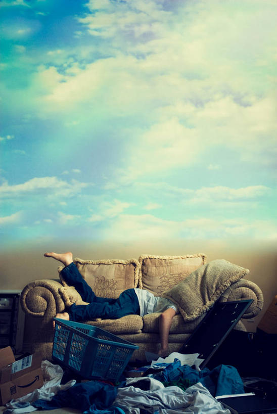 一个人,竖图,室外,白天,沙发,美国,朦胧,模糊,纸箱,云,凌乱,牛仔裤,休闲装,洗衣服,枕头,趴着,赤脚,摄影,洗衣篮,彩图,家务劳动