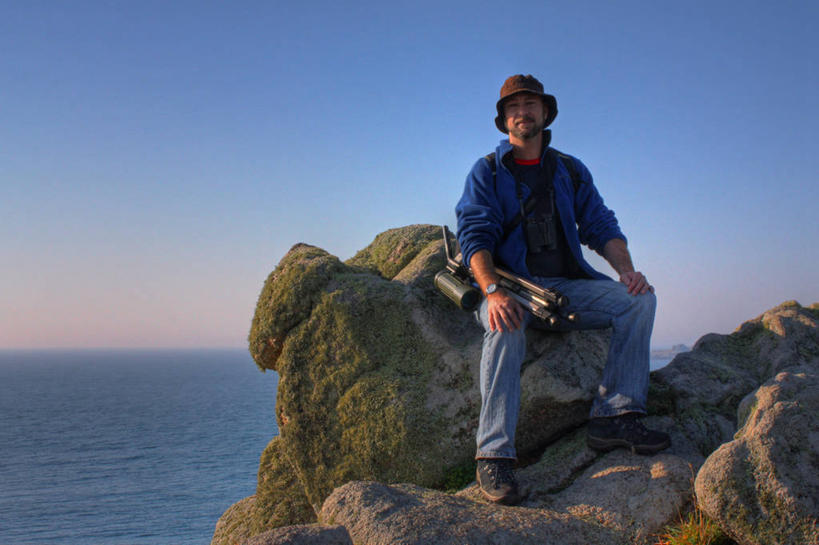 西方人,成年人,中年人,老年人,一个人,坐,横图,室外,白天,海洋,英国,欧洲,欧洲人,仅一个男性,仅一个人,仅一个中年男性,地形,水平线,牛仔裤,休闲装,设备,物品,自然,摄影,宁静,肖像,男人,男性,中年男性,白种人,岩石,彩图,利岛