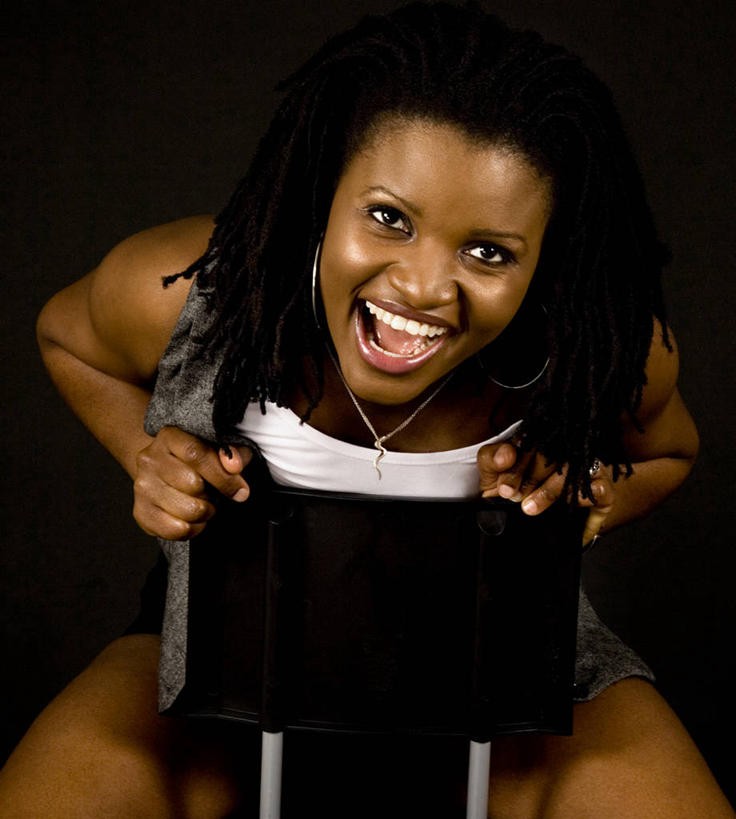 成年人,一个人,笑,微笑,露齿笑,竖图,幸福,椅子,仅一个年轻女性,仅一个女性,仅一个人,黑色背景,摄影,肖像,年轻女性,女人,女性,年轻人,彩图,影棚拍摄,雷鬼头,暗调