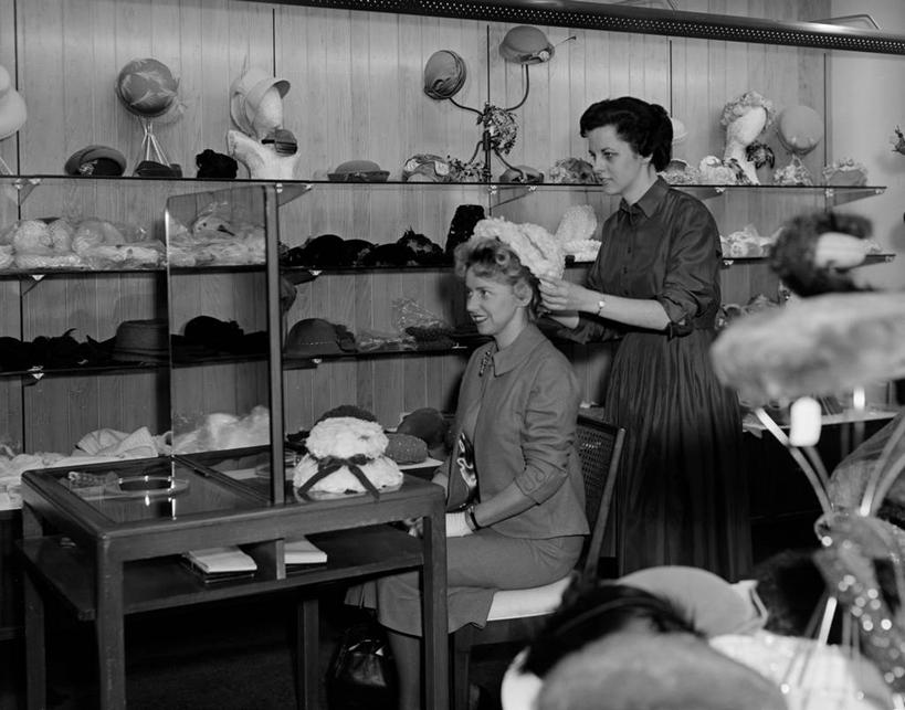 成年人,中年人,老年人,两个人,商店,站,坐,微笑,横图,黑白,室内,白天,侧面,购物,桌子,帽子,商品,古典,拿着,顾客,架子,试穿,思考,零售,服务,摄影,服装店,选择,老年女性,中年女性,售货员,过去