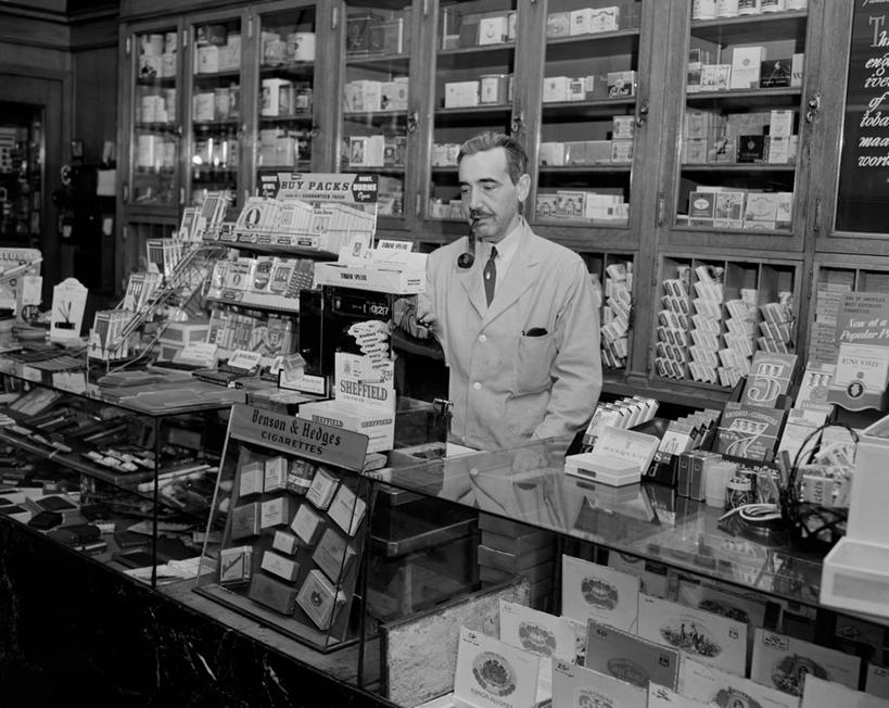 成年人,中年人,老年人,一个人,商店,站,吸烟,横图,黑白,室内,正面,美国,仅一个男性,仅一个人,仅一个中年男性,拿着,架子,职业,摄影,烟斗,波士顿,马萨诸塞,想法,男人,男性,中年男性,售货员,烟草,半身