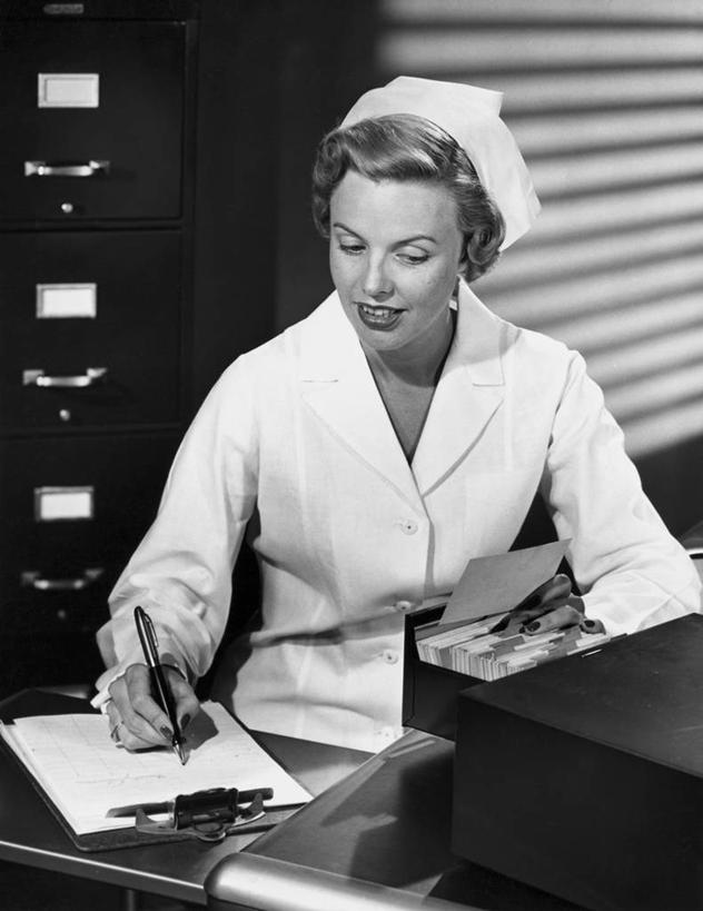 西方人,一个人,护士,医院,坐,微笑,竖图,黑白,室内,制服,桌子,帽子,抽屉,欧洲,欧洲人,写,注视,水笔,观察,看,服务,摄影,观看,写字板,察看,白衣天使,关注,实验服,女性,白种人,年轻人,半身