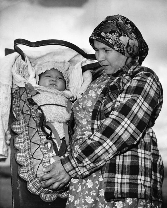 西方人,婴儿,儿童,成年人,中年人,老年人,两个人,家庭,父母,母亲,微笑,竖图,黑白,室外,白天,婴儿服装,纯洁,纺织品,欧洲,加拿大,欧洲人,头巾,头饰,热,注视,小孩,发饰,观察,看,温暖,温馨,一家人,可爱,童年,摄影,活泼,观看,和睦,察看,关爱,关注,运送,宝宝,纯真,烂漫,无邪,伶俐,天真,老年女性,中年女性,白种人,美国人,孩子,半身,爱,融洽,月,婴儿背带,对焦