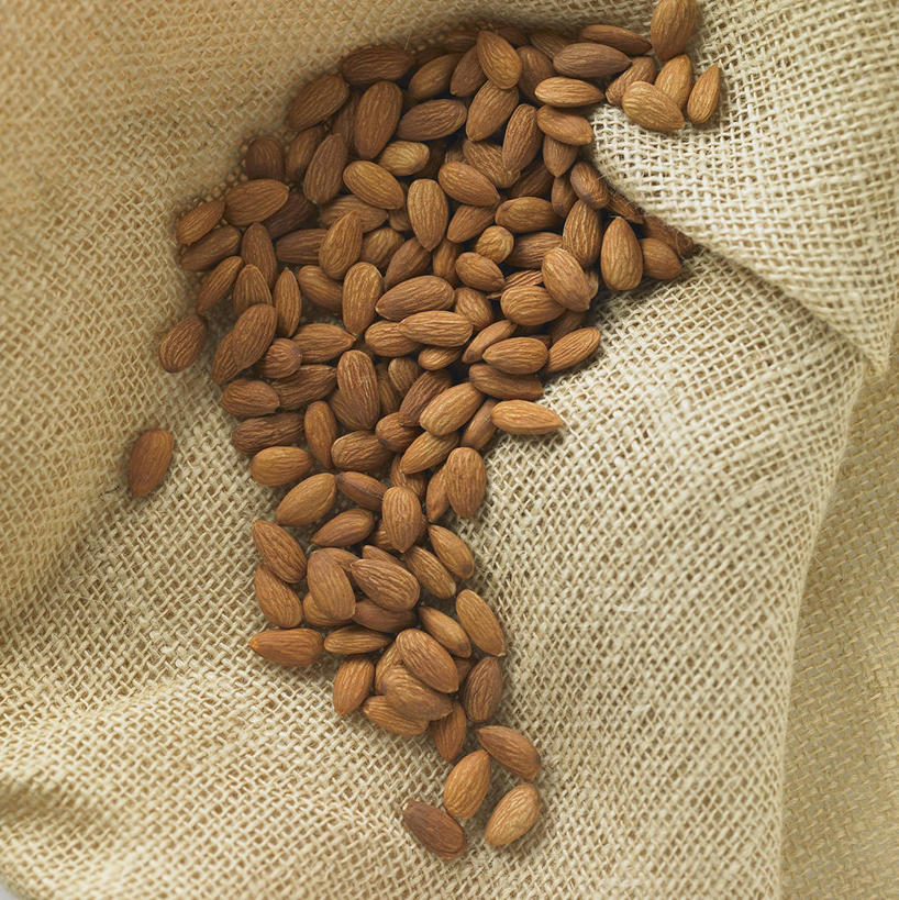 无人,竖图,俯视,室内,特写,白天,杏仁,纺织品,一堆,许多,阴影,堆叠,堆积,反射,布,影子,坚果,果实,织物,很多,干果,堆,麻布,杏子,杏梅仁,杏核仁,木落子,苦杏仁,彩图,高角度拍摄