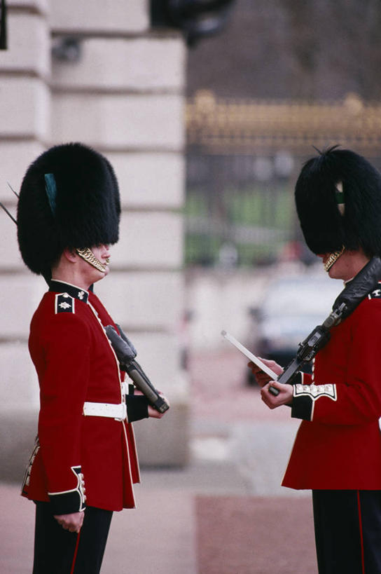 两个人,宫殿,竖图,城市,英国,欧洲,行人,游客,游人,军事,首都,英格兰,白金汉宫,路人,旅客,衣服,地标建筑,摄影,保护,军服,英国文化,皇室,过客,彩图,军官,传统文化,名声,军团