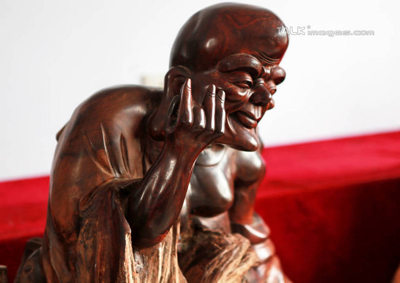东方人,一个人,无人,和尚,坐,举,笑,微笑,横图,室内,白天,正面,静物,雕塑,亚洲,仅一个男性,仅一个人,仅一个中年男性,阴影,节日,艺术,装饰,光线,光泽,木制,雕刻,雕像,佛像,影子,墙,棕色,织物,光芒,黄种人,文化,墙壁,墙面,红色,白色,阳光,木制品,工艺品,祈祷,托,健康,展示,许愿,宗教,根雕,佛教,信仰,纪念,展览,支撑,祈求,美术,主题,陈列,罗汉,功能,美学,释教,阿罗汉,那迦犀那,那迦犀那尊者,十八罗汉,挖耳罗汉,绒布,平安,男人,男性,中年男性,亚洲人,比丘,高僧,僧,僧侣,僧人,沙弥,修行僧,举起,举手,举着,向上举,向上伸,向上托,坐着,半身,彩图,rzwdb1