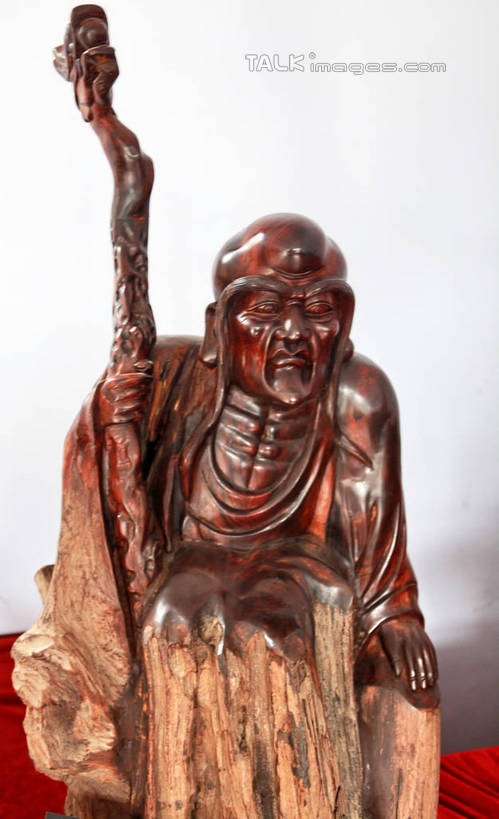 东方人,一个人,无人,和尚,站,笑,微笑,竖图,室内,白天,正面,静物,雕塑,亚洲,仅一个男性,仅一个人,仅一个中年男性,阴影,节日,艺术,装饰,光线,光泽,木制,雕刻,雕像,佛像,影子,墙,棕色,织物,光芒,黄种人,文化,墙壁,墙面,红色,白色,阳光,木制品,工艺品,祈祷,站着,健康,展示,许愿,宗教,根雕,佛教,信仰,拐杖,纪念,展览,支撑,祈求,美术,主题,陈列,罗汉,功能,美学,释教,阿罗汉,阿氏多,阿氏多尊者,十八罗汉,长眉罗汉,绒布,平安,男人,男性,中年男性,亚洲人,比丘,高僧,僧,僧侣,僧人,沙弥,修行僧,站立,半身,彩图,拄着,rzwdb1