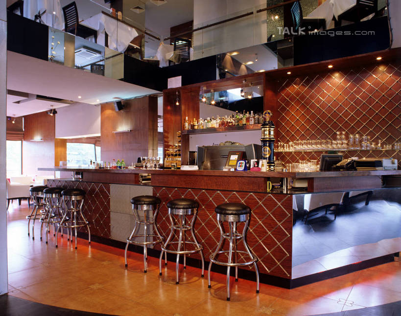 无人,酒吧,栏杆,横图,室内,白天,正面,吧台,餐桌,桌子,杯子,椅子,阴影,反射,瓷砖,地砖,高脚杯,影子,墙,围栏,走道,走廊,过道,红酒杯,地面,护栏,墙壁,墙面,玻璃制品,酒杯,服务台,餐台,吧椅,葡萄酒杯,吧台椅,酒吧椅,玻璃杯,彩图,酒吧间,酒馆,酒吧台,szzm1