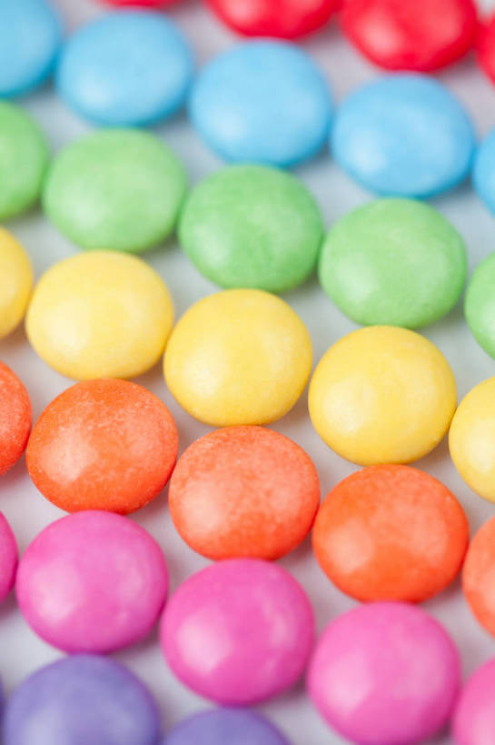 无人,竖图,俯视,彩色,室内,特写,白天,白色背景,一排,许多,整齐,并列,并排,食品,糖,糖果,甜点,甜品,巧克力豆,很多,食物,排列,甜食,巧克力,摄影,影棚,朱古力,五颜六色,色彩斑斓,队列,五彩缤纷,平行,五彩斑斓,五光十色,彩图,高角度拍摄,影棚拍摄,拍摄